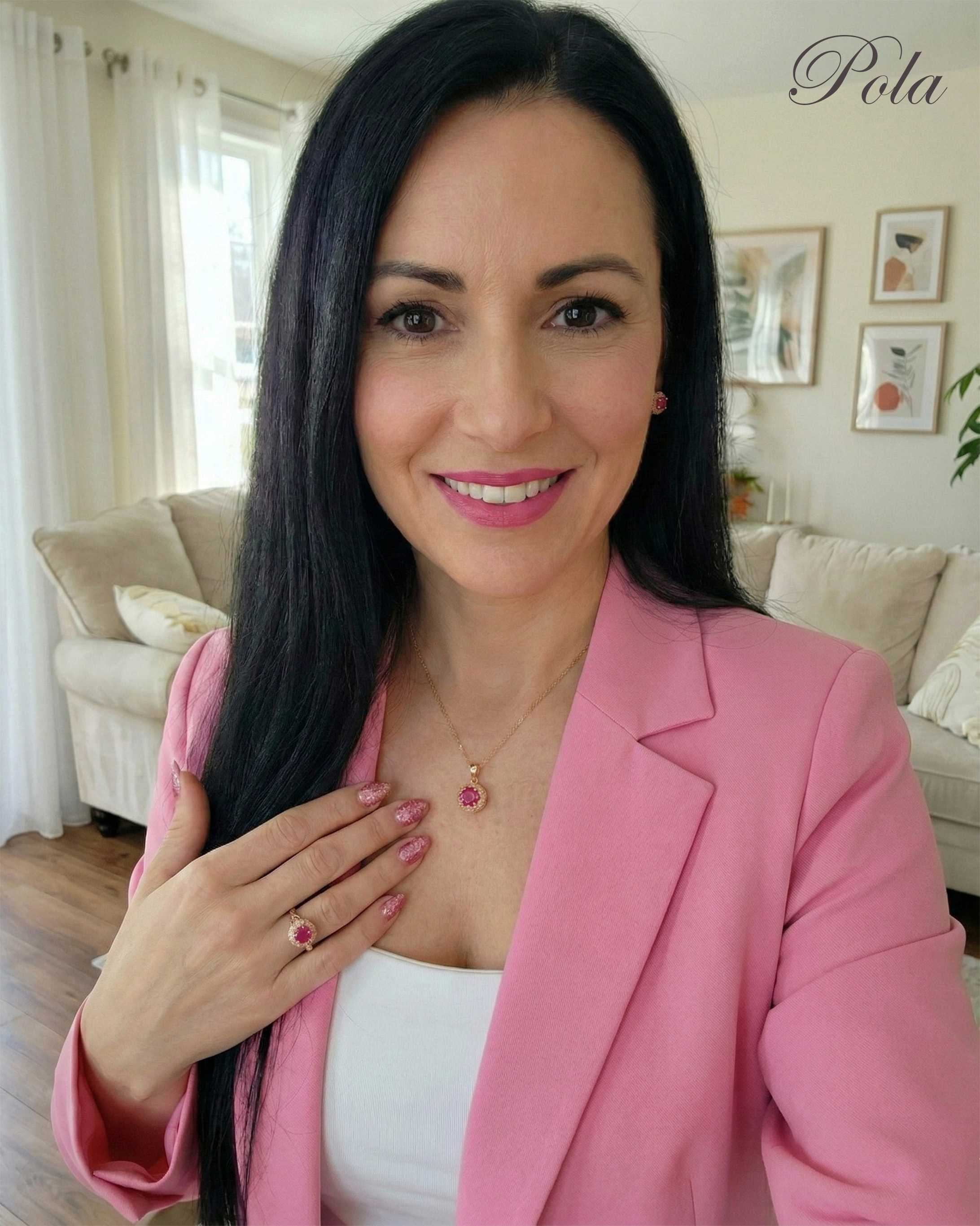 Kobieta w różowej marynarce nosząca piękny pierścionek z rubinem oraz dopasowany naszyjnik.